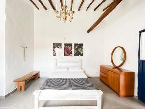 ein weißes Schlafzimmer mit einem Bett und einem Spiegel in der Unterkunft Unique House Elena Barichara Open Space Bright in Barichara