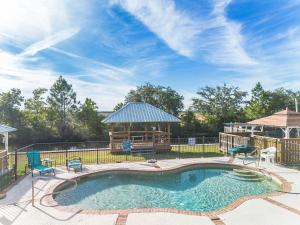 une piscine avec des chaises et un gazebo dans l'établissement Waterfront Home with Pool by Next Step Property Management, à Pass Christian