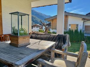 a wooden table with a potted plant on a patio at KITZHORN EMOTIONS near skilift by Belle-Stay in Jochberg