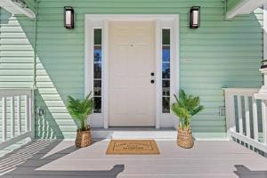 une porte d'entrée accueillante d'une maison verte avec un paillasson de bienvenue dans l'établissement Waterfront Home with Pool by Next Step Property Management, à Pass Christian 25 autres photos