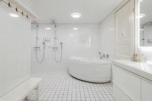 ヴァンターにあるNordic Nest Bの浴槽とシャワー付きの白いバスルーム