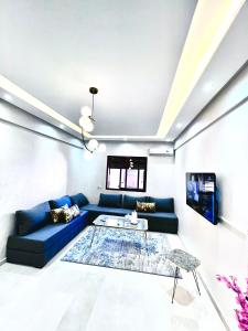 Una sala de estar con un sofá azul y una mesa. en Marrakech Gueliz Rue zellaqa, en Marrakech