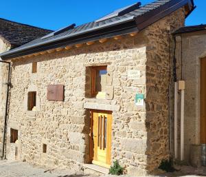 an old stone building with a yellow door at L'Orri in Dorres