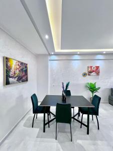 Un comedor con una mesa y sillas negras. en Marrakech Gueliz Rue zellaqa, en Marrakech