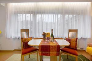a dining room table with two chairs and a window at Ferienwohnung Grünfelder in Au