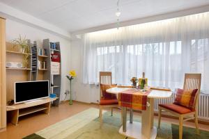 a living room with a dining room table and a television at Ferienwohnung Grünfelder in Au