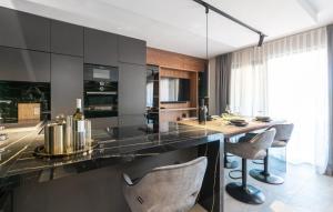 cocina con encimera negra y 2 sillas en Val di Bora 2, en Poreč