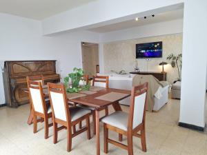 a dining room with a table and chairs and a living room at Microcentro - 4 Personas - 2 dormitorios - Cochera in Santiago del Estero