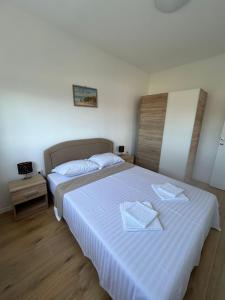 a bedroom with two beds with white sheets at Galešnjak in Sveti Petar