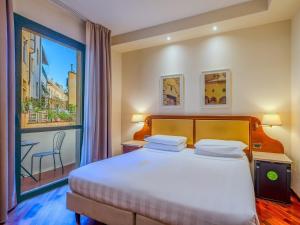 a hotel room with a bed and a large window at B&B Hotel Firenze Pitti Palace al Ponte Vecchio in Florence