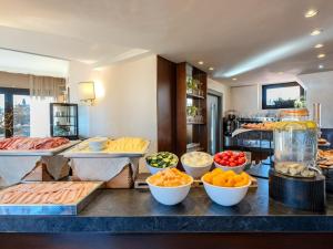a buffet with various fruits and vegetables on a counter at B&B Hotel Firenze Pitti Palace al Ponte Vecchio in Florence