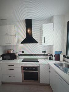 a kitchen with a sink and a stove top oven at Large terrace and views in Retamar