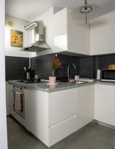 a kitchen with white cabinets and a sink at Homey Apartment Obor in Bucharest