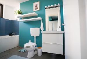 a bathroom with a toilet and a sink and a mirror at Homey Apartment Obor in Bucharest +16 photos