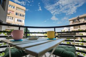 a table with two cups on top of a balcony at Homey Apartment Obor in Bucharest