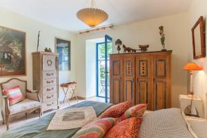 een slaapkamer met een bed, een stoel en een dressoir bij Casa La Colombaia in Poggio-di-Nazza