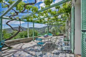 een patio met een tafel en stoelen en uitzicht bij Casa La Colombaia in Poggio-di-Nazza +38 foto's