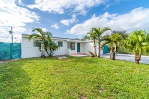 a white house with palm trees in a yard at Cozy Hollywood Private Pool Retreat - Ping pong in Hollywood