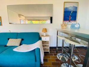 a living room with a blue couch and a table at Le bleu de George Sand, vue mer exceptionnelle in La Seyne-sur-Mer