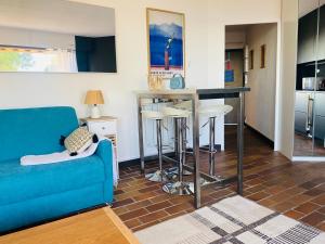 a living room with a blue couch and a kitchen at Le bleu de George Sand, vue mer exceptionnelle in La Seyne-sur-Mer +17 photos