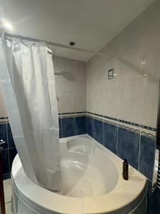 a bathroom with a tub and a toilet in a room at Wood Green Central Cozy Rooms in London +15 photos