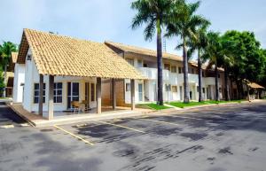 a row of buildings with palm trees and a street at Resort Internacional DiRoma in Caldas Novas