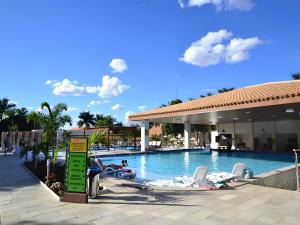 a swimming pool with lounge chairs and people in a resort at Resort Internacional DiRoma in Caldas Novas