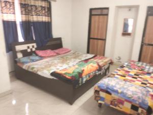 a bedroom with two twin beds in a room at Gurukrupa Home stay in Rājpīpla +7 photos