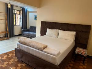a bedroom with a large bed and a couch at Kivuli Inn in Moshi