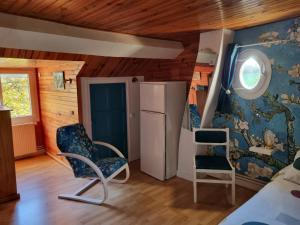a room with two chairs and a refrigerator at Chambres à l'Orée du bois in Souancé-au-Perche
