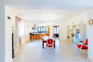 a dining room with a table and red chairs at La Gardère - Villa Sarlat in Sarlat-la-Canéda