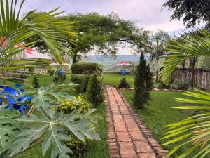 a garden with a brick path and palm trees at Vilimani Garden Residence in Rwamagana
