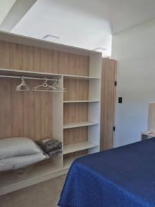 a bedroom with a bed and shelves in it at VerdeMar Loft - Gamboa Beach - SC in Garopaba