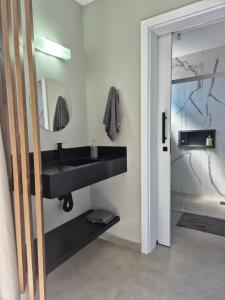 a bathroom with a black sink and a mirror at VerdeMar Loft - Gamboa Beach - SC in Garopaba
