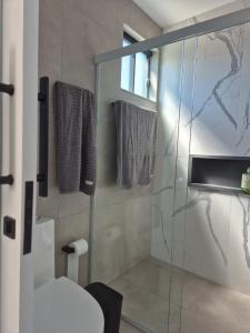 a bathroom with a glass shower with a toilet at VerdeMar Loft - Gamboa Beach - SC in Garopaba +25 photos