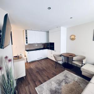 a kitchen and living room with white cabinets and a table at Studio 9 Żeromskiego in Gorzów Wielkopolski