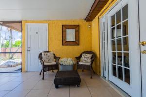 黎明城Family Oasis at Sunrise Private Pool, Game, Cardio, Grill, Work & Play的门廊配有两把椅子、一张桌子和镜子 更多50张照片