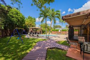 黎明城Family Oasis at Sunrise Private Pool, Game, Cardio, Grill, Work & Play的一个带游乐场和秋千的庭院