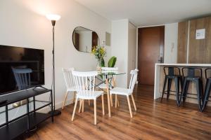 a living room with a table and chairs and a mirror at Luxury and Comfort in the Heart of Las Condes in Santiago