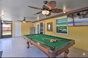 a pool table in a room with a ceiling fan at Family Oasis at Sunrise Private Pool, Game, Cardio, Grill, Work & Play in Sunrise