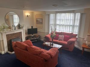 a living room with two couches and a fireplace at The Beaumont in Sittingbourne