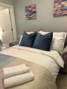 a bed with blue and white pillows in a room at Cosy Ground-Floor Flat in Omagh Centrally located in Omagh