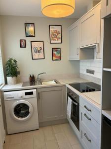 a kitchen with a washing machine and a sink at Cosy Ground-Floor Flat in Omagh Centrally located in Omagh