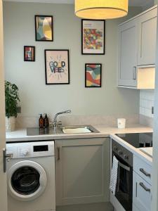 a kitchen with a washing machine and a sink at Cosy Ground-Floor Flat in Omagh Centrally located in Omagh +5 photos