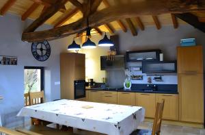 una cocina con una mesa y una cocina con un reloj en Gite De Caractère En Pleine Nature, en Bourg-de-Visa