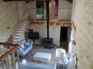 Una sala de estar con un sofá y una chimenea. en Gite De Caractère En Pleine Nature, en Bourg-de-Visa