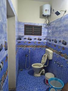 ein blaues Bad mit einem WC und einer Dusche in der Unterkunft Aravindh's Chendur HomeStay in Tiruchchendūr + 11 Fotos