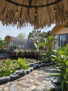 a resort with a patio with plants and a building at TamCoc Moon An Bungalow & Cafe in Ninh Binh