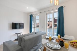 a living room with a couch and a table with food on it at Largo da Praça Boutique by Sé Apartamentos in Braga