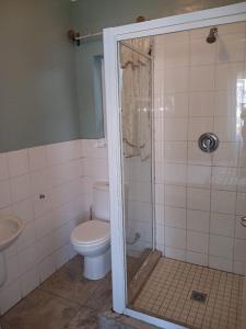 a bathroom with a toilet and a glass shower at Lookout Star Legend Accommodation in Parow